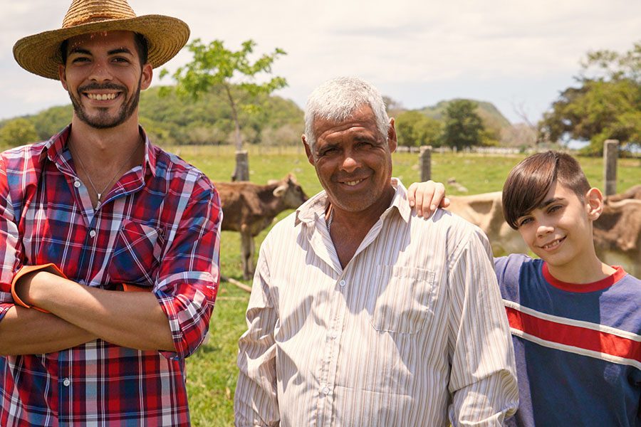 About Our Agency - Three Generations Family Portrait Of Farmers In Farm on a Sunny Day